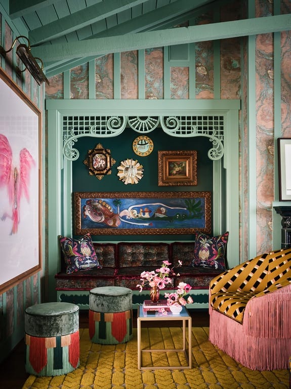 Eclectic living room with colorful patterned furniture, wall art, and unique decor in a cozy setting.