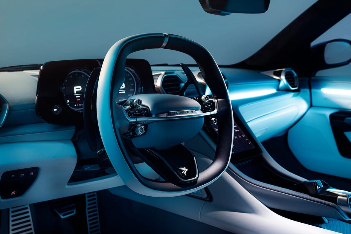 Close-up view of a modern car steering wheel and digital dashboard in a sleek, futuristic vehicle interior setting.
