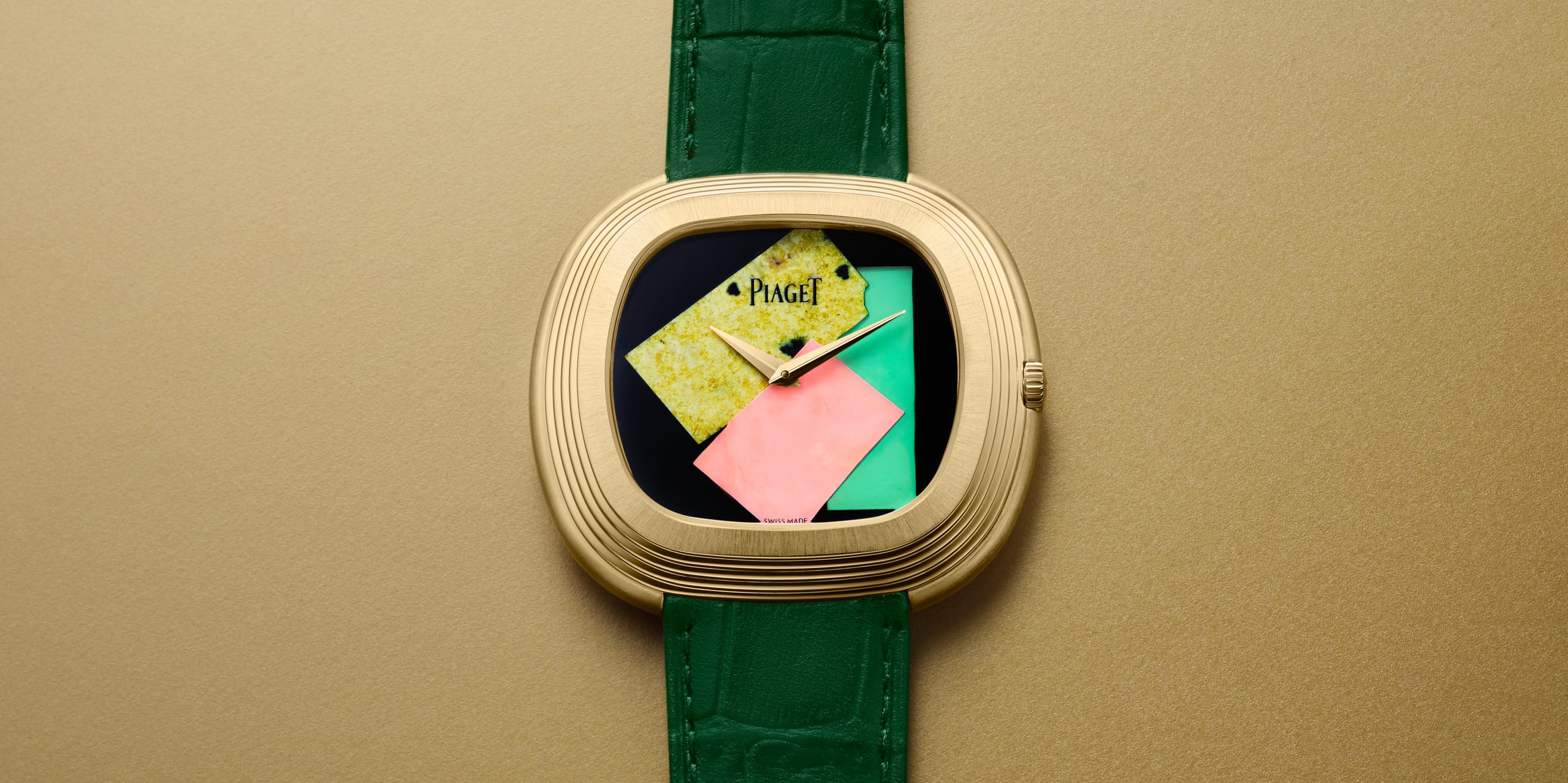 Luxury gold watch with geometric design on face, featuring green strap against a gold background.
