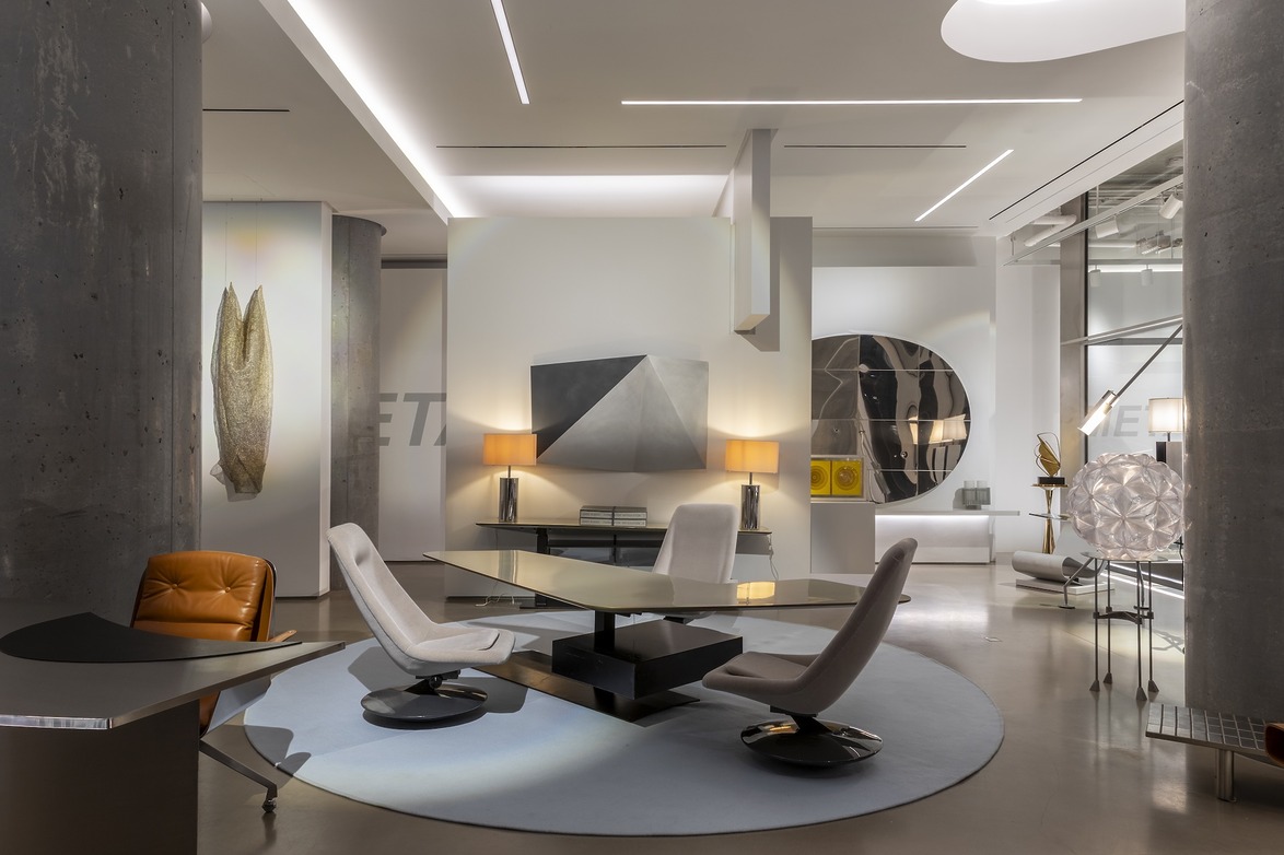 Modern office space with contemporary furniture, abstract art on walls, and unique lighting fixtures in a sleek, minimalist design.