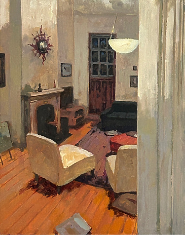 cozy living room with two white chairs, a fireplace, and a wooden floor, viewed through a doorway