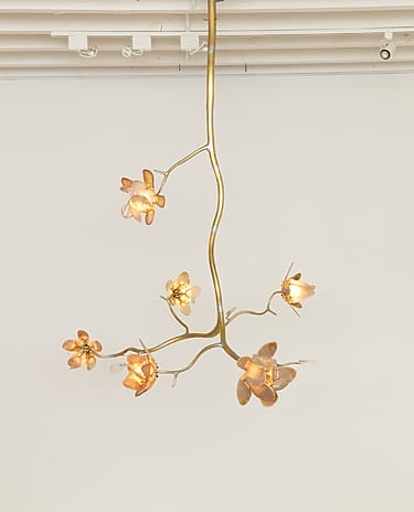 Elegant gold ceiling light fixture with floral-shaped bulbs hanging against a plain white background.