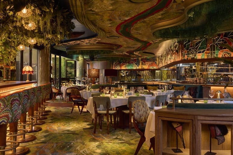 Luxurious restaurant interior with artistic decor, vibrant colors, and elegantly set tables, creating an inviting dining atmosphere.