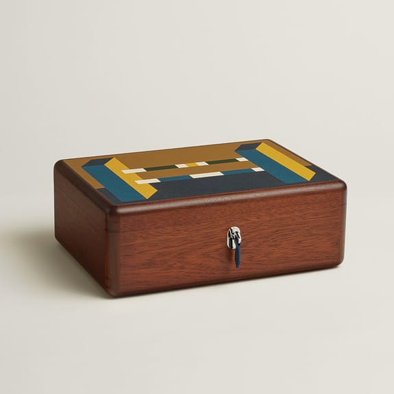 Wooden box with colorful geometric pattern on lid and a silver keyhole on the front.