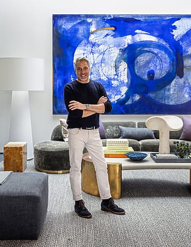 Person standing in a stylish living room with modern art and contemporary furniture.