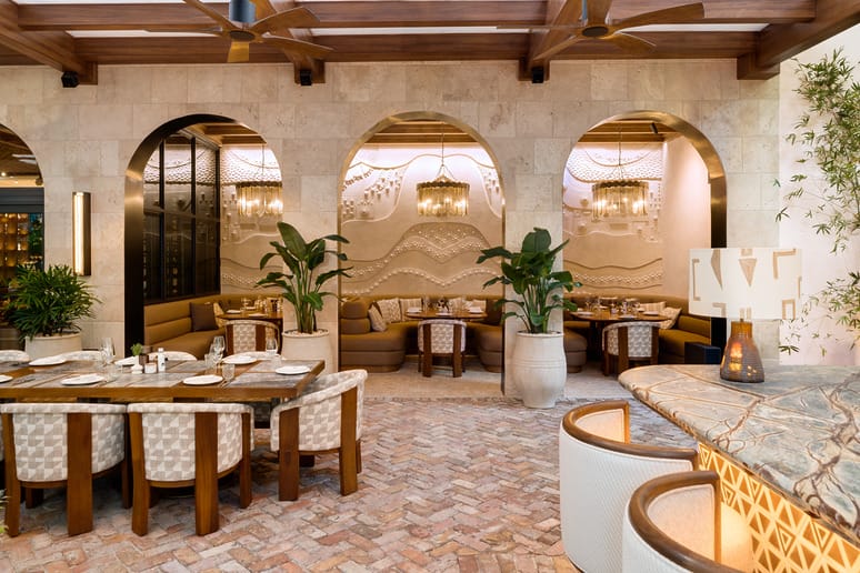 Luxurious restaurant interior with elegant arches, cozy seating, decorative plants, and ambient lighting.