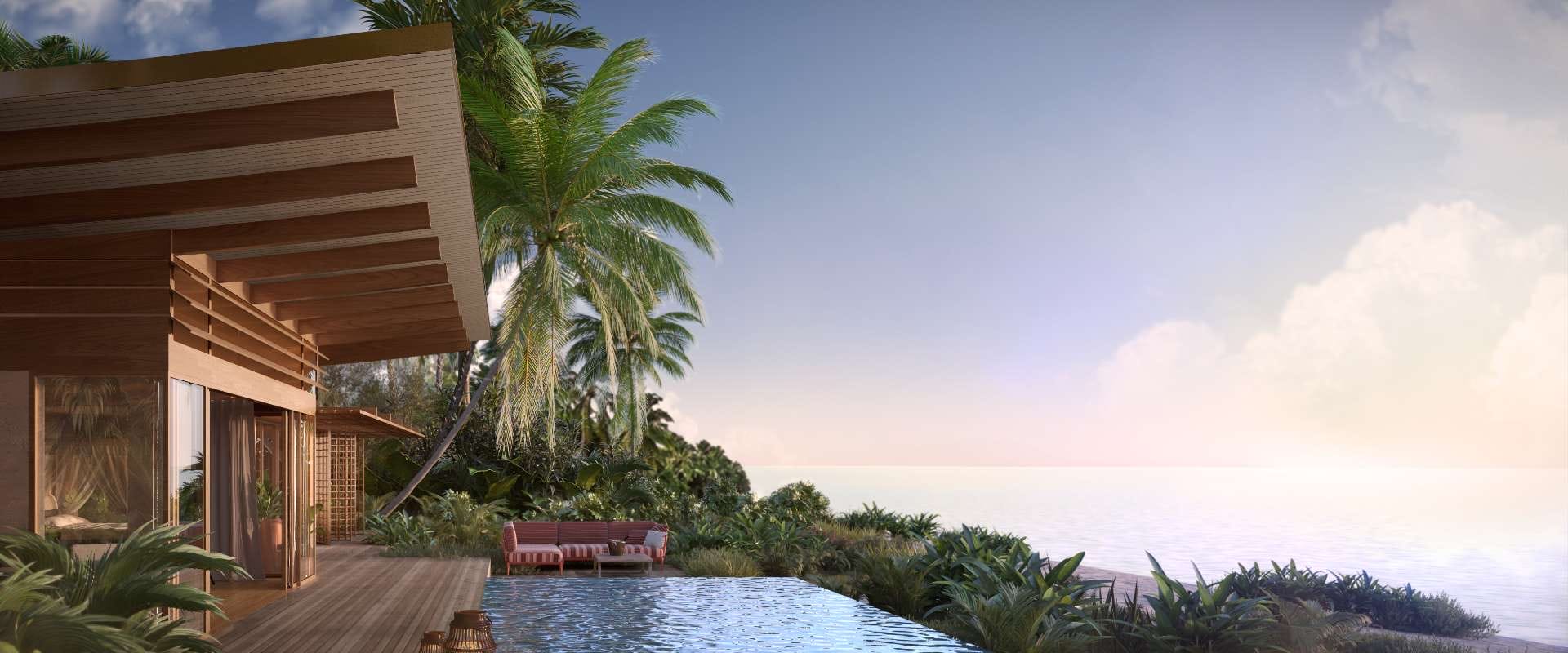 Modern villa with wooden deck and pool overlooking a tropical beach at sunset, surrounded by lush greenery and palm trees.