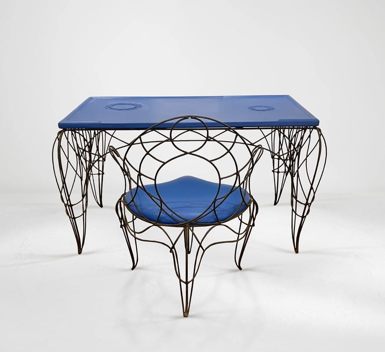 Blue glass-top table with intricate wire legs and matching wire-framed chair on a white background.