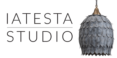 Iatesta Studio logo featuring a pendant light with a layered, leaf-like design in a metallic finish.