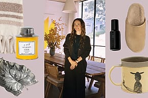 Woman in a cozy dining room with various home items around her, including a blanket, mug, and slippers.