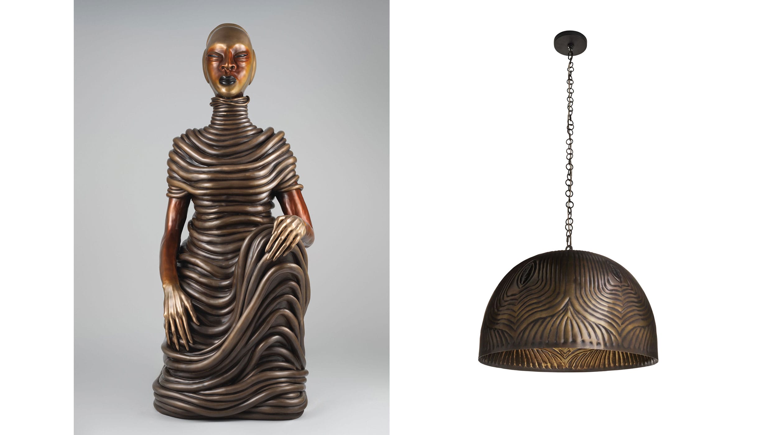 Sculpture with intricate flowing design and mask-like face next to an ornate hanging lamp with wavy pattern.