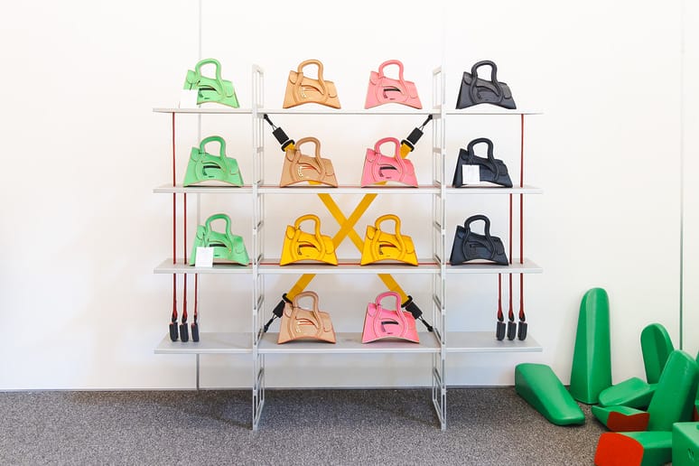 Colorful bags on shelves with attached jump ropes, arranged in a bright room with padded green shapes on the floor.