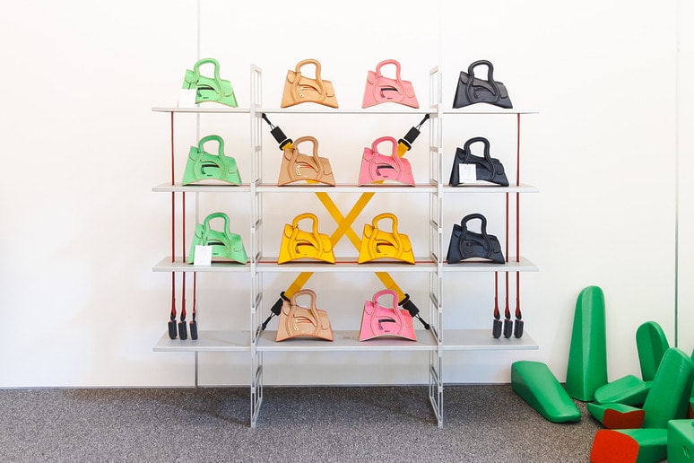 Colorful bags on shelves with attached jump ropes, arranged in a bright room with padded green shapes on the floor.