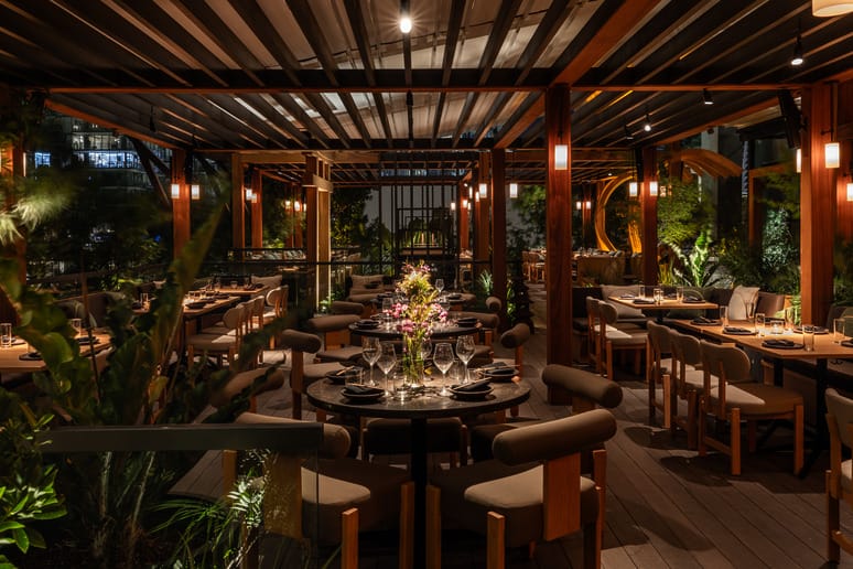Cozy outdoor restaurant setting at night with elegant table arrangements and ambient lighting.