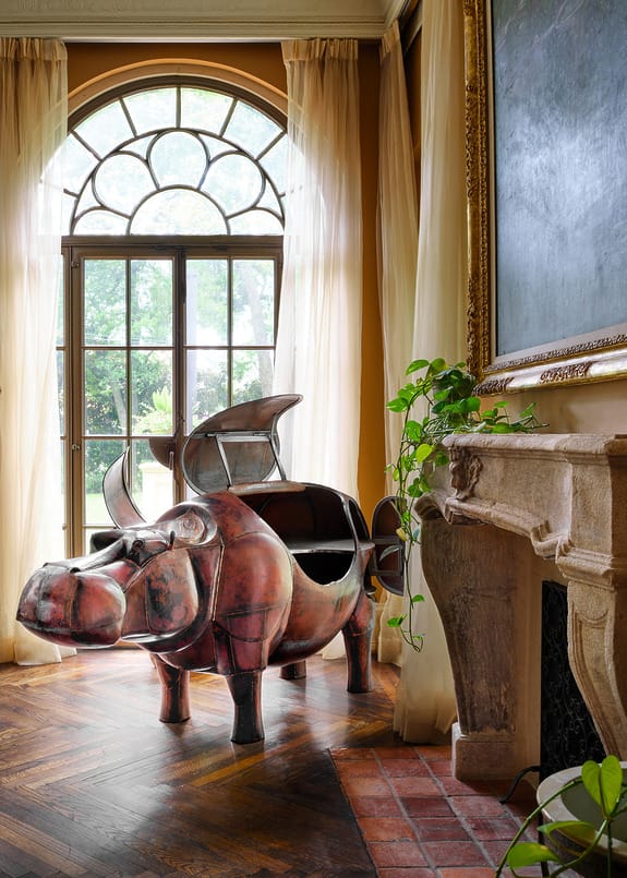 優雅的房間裡擺放著造型獨特的河馬形葡萄酒冷藏櫃，房間裡有大窗戶、綠植和木地板。