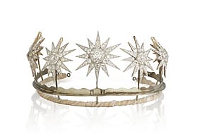 A diamond tiara featuring star-shaped gemstone designs on a simple metal band.