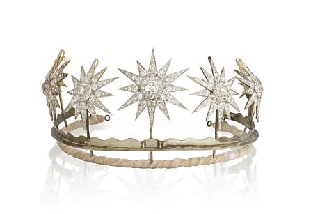 A diamond tiara featuring star-shaped gemstone designs on a simple metal band.
