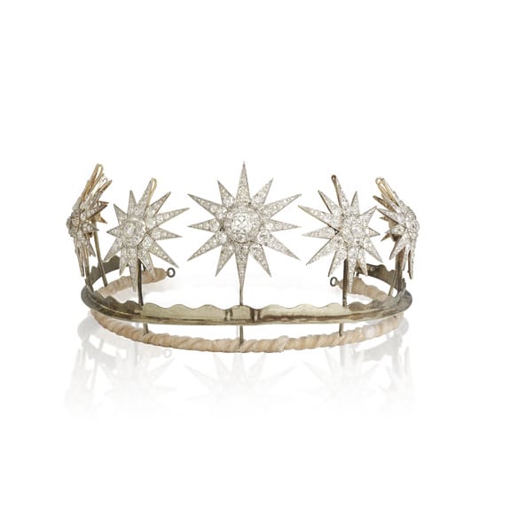 A diamond tiara featuring star-shaped gemstone designs on a simple metal band.