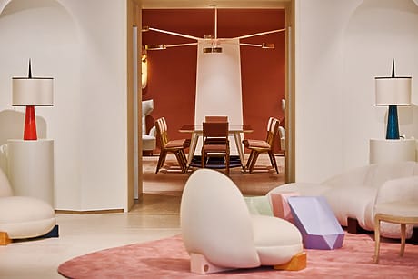 Modern interior with stylish furniture, soft seating, vibrant accent lamps, and a spacious dining area with a unique chandelier.