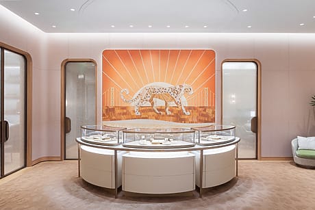 Luxury jewelry store interior featuring elegant display cases and a large, artistic cheetah mural on the wall.