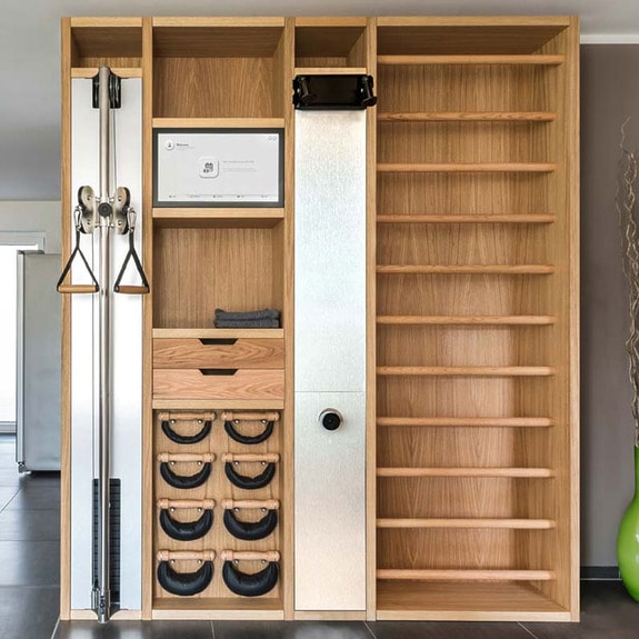 Modern wooden home gym installation with pulleys, shelves, and integrated storage in a stylish residential space.