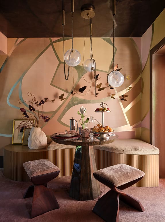 Eclectic dining area with modern table, abstract wall art, pendant lights, and decorative plants.