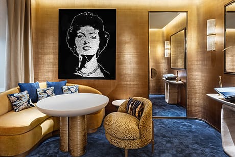 Luxurious modern living room with portrait artwork, curved sofa, stylish decor, and elegant lighting fixtures.