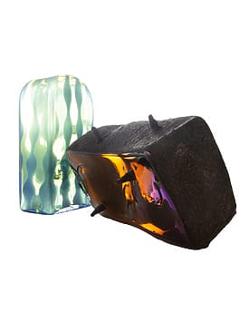 Colorful abstract glass sculptures with smooth, wavy textures and iridescent surfaces, one black and glossy, the other translucent.