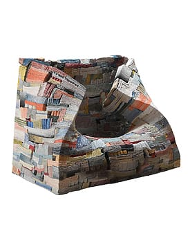 Abstract, colorful chair made of stacked textile layers, resembling a patchwork design with various textures and colors.
