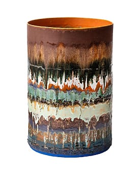 Colorful ceramic vase with a layered, abstract design featuring earthy tones, blue, and green accents.