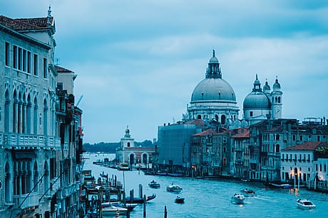 Scenic view of the Grand Canal in Venice, Italy, with historic architecture and boats under a cloudy sky.