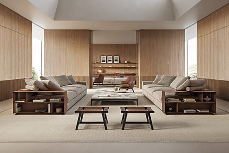 Modern living room with wooden walls, two beige sofas, a desk in the background, and two small tables in the center.