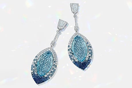 Elegant silver and blue gemstone earrings with intricate design on a white background.