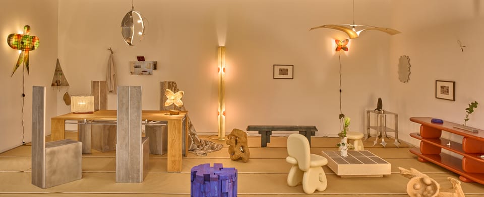 Contemporary art installation featuring abstract sculptures and modern furnishings in a minimalist gallery space.