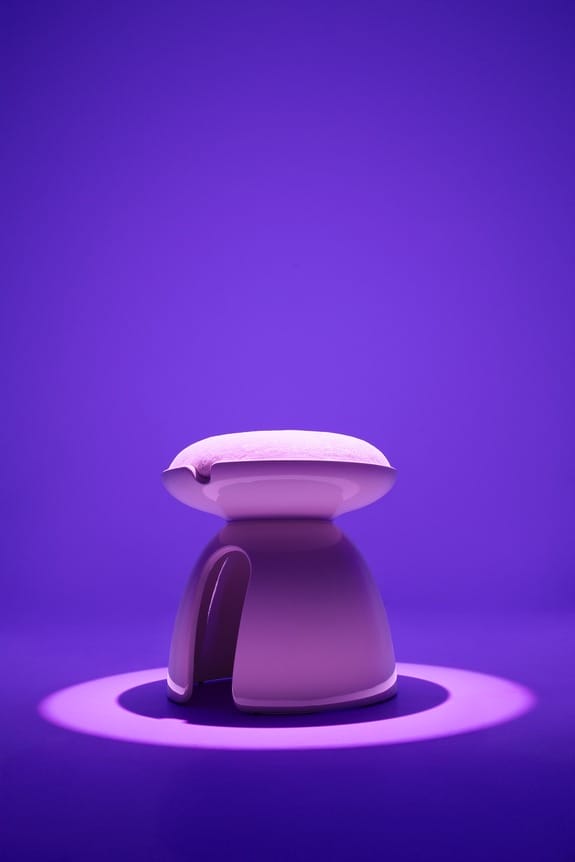 Modern purple stool under spotlight on a purple background, casting a shadow on the floor.