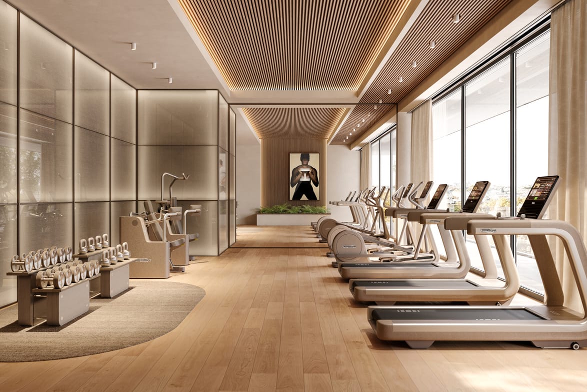 modern gym with treadmills, exercise bikes, and weight racks in a spacious, well-lit room with wooden floors and ceiling