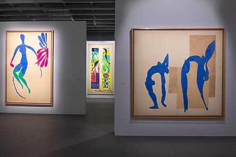 Art gallery at the Grand Palais's Matisse exhibition featuring colorful abstract cutout figures displayed in large frames on white walls.