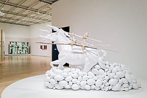 White horse sculpture with arrows and balloons in an art gallery display.