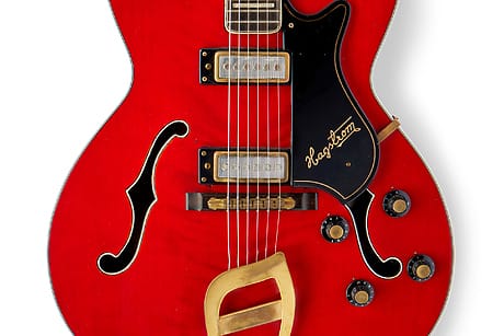 Red semi-hollow electric guitar with gold hardware, dual pickups, black pickguard, and sound holes on a white background.