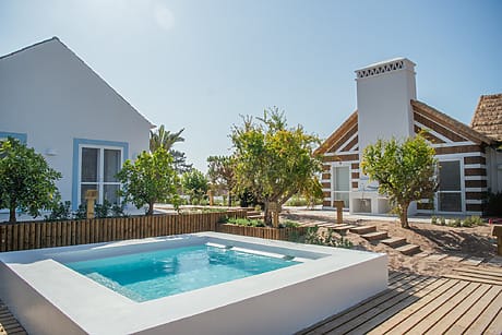 cozy outdoor pool in a sunny backyard with two charming cottages