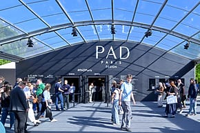 People entering PAD Paris Design event under a large, transparent canopy with the PAD Paris sign above.