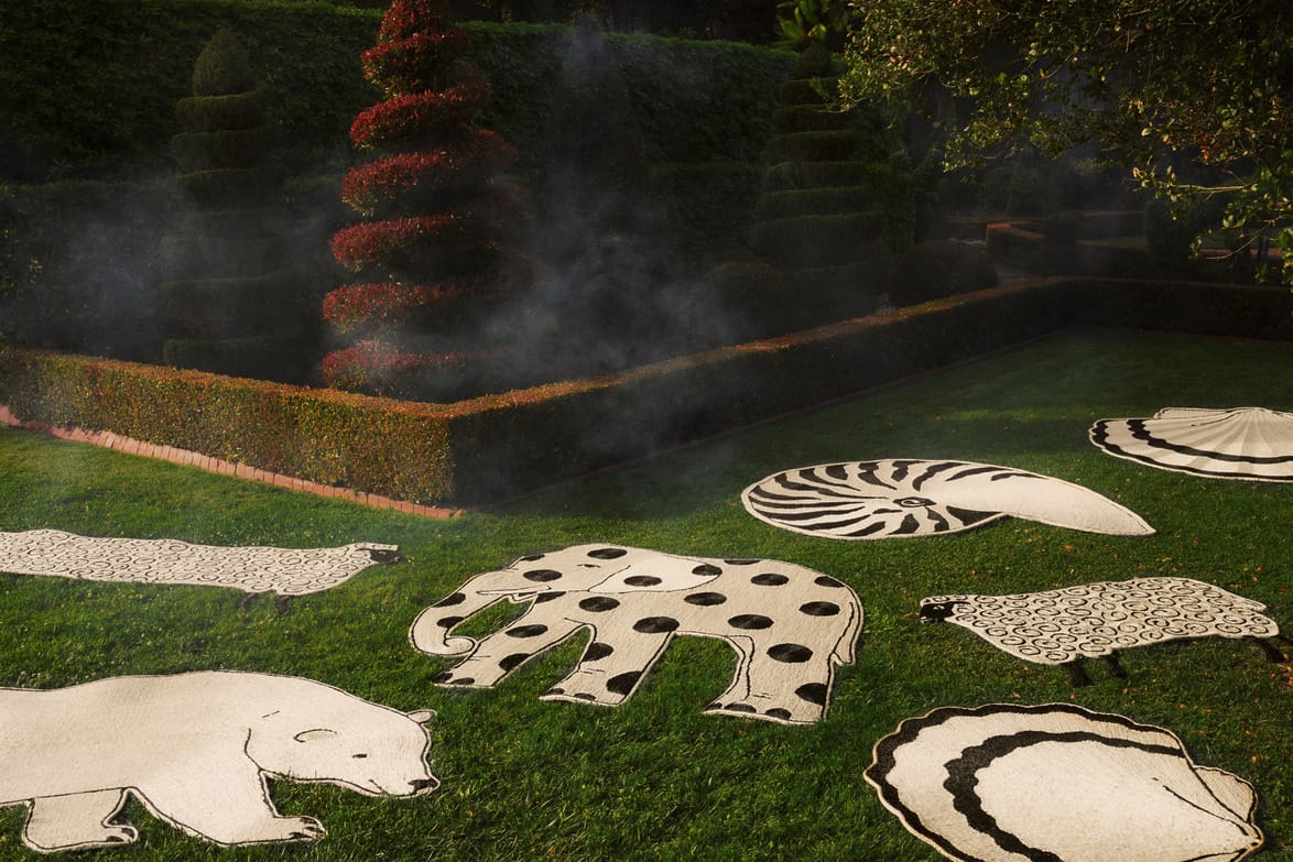 Charlap Hyman & Herrero for Patterson Flynn rugs depicting animals and shells arranged on a lawn with manicured hedges and spiral-shaped topiary.
