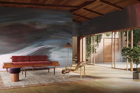 Modern living room with abstract wall mural, wooden ceiling, red sofa, armchair, plants, and large glass doors.