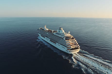 cruise ship sailing on open ocean with a clear sky in the background