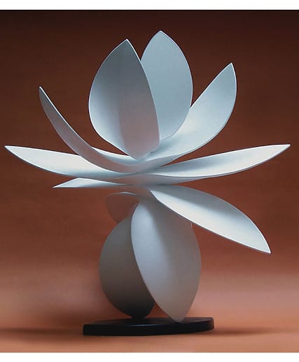 Abstract white sculpture with overlapping petal-like shapes against a smooth brown background.