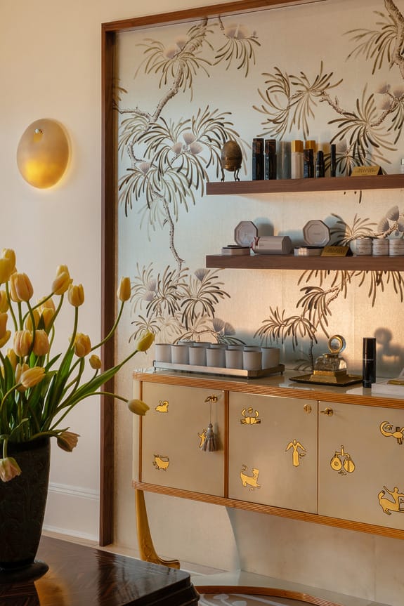 Stylish bathroom with decorative wallpaper, shelves, and tulips in a vase, enhancing the luxurious ambiance.