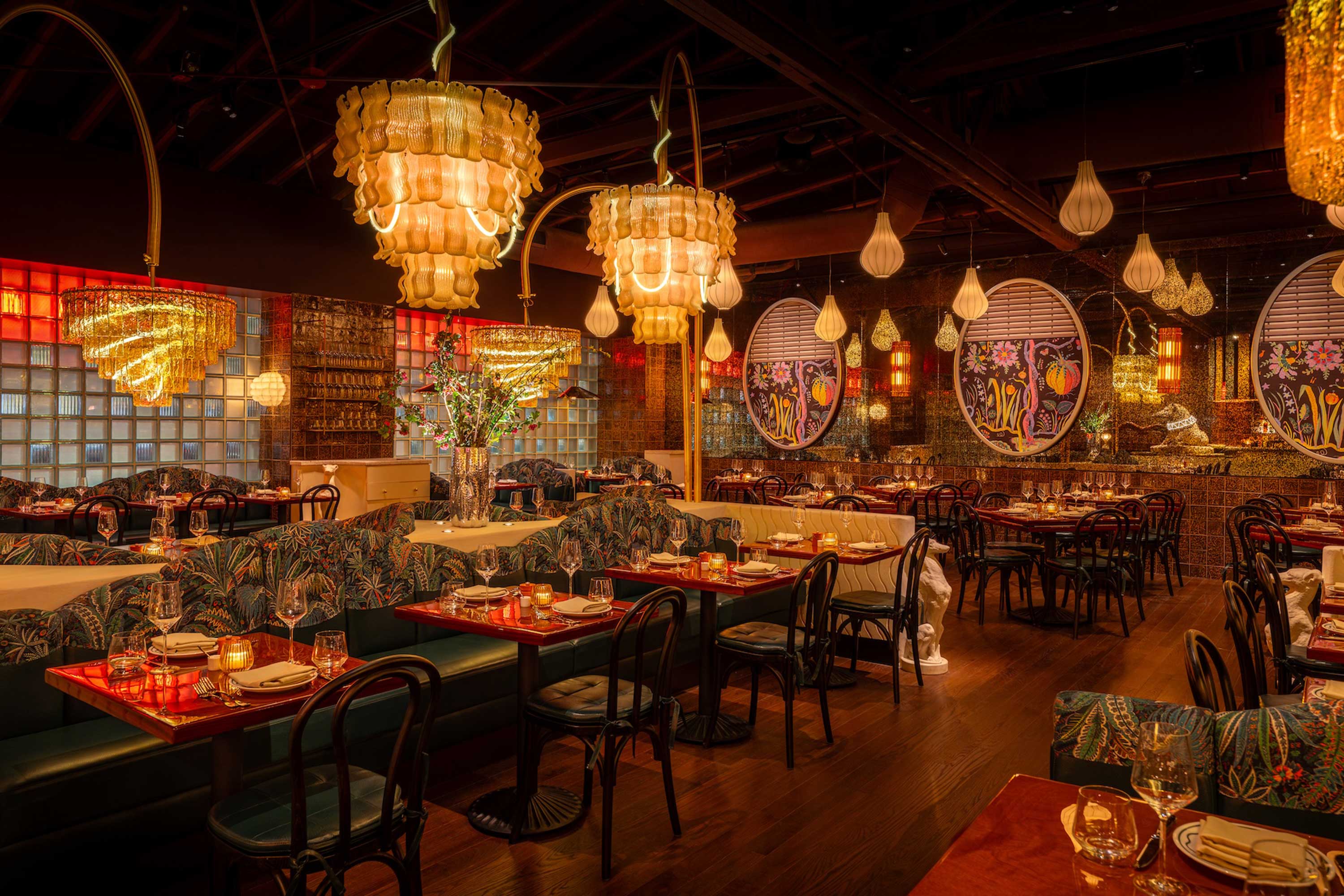 Cozy restaurant interior with warm lighting, elegant chandeliers, and beautifully set tables ready for dining.